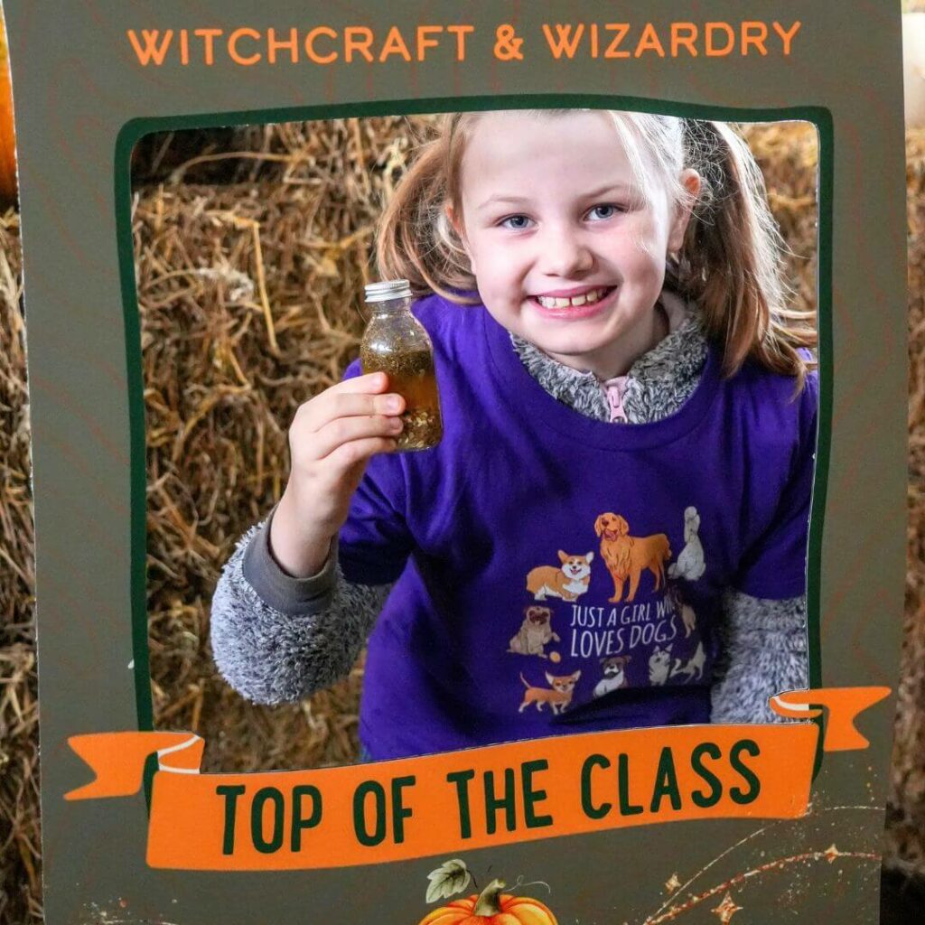 Young girl holding a Halloween potion - Hogshaw School of Witchcraft & Wizardry